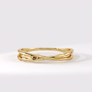 Könnte beinhalten: Ein goldener Ring mit einem Doppelband-Design und einer gewellten, gedrehten Textur. Auf der Innenseite des Rings ist deutlich der Schriftzug LUCY'S 14K eingraviert, der die Materialzusammensetzung dieses polierten Gelbgoldschmucks angibt.