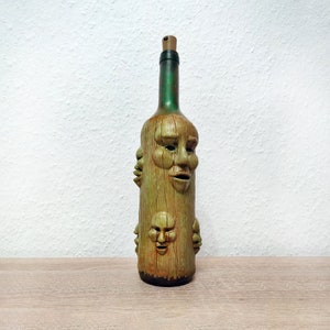 Bottle decorated with scary faces with LED lights, wooden texture, night light