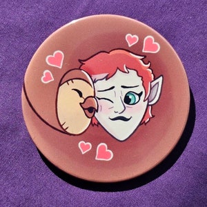 May include: A brown and white cartoon bird is kissing a red-haired character with green eyes on a brown background with pink hearts.