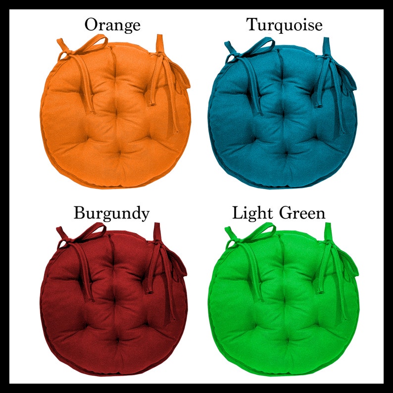May include: Four round chair cushions in different colours: orange, turquoise, burgundy, and light green. Each cushion has a tie on each side.