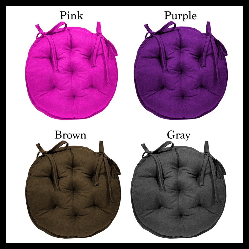 May include: Four round chair cushions with ties. The cushions are in pink, purple, brown, and grey.