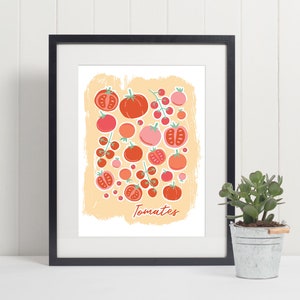 Pu&ograve; includere: Una stampa incorniciata con un'illustrazione colorata di pomodori su uno sfondo pesca. La stampa ha la parola "Tomates" scritta in basso.