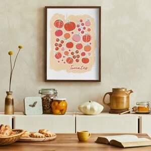 Pu&ograve; includere: Una stampa incorniciata con un'illustrazione colorata di pomodori in varie tonalit&agrave; di rosso e rosa. La stampa &egrave; su uno sfondo beige chiaro con la parola "Pomodori" scritta in un carattere stilizzato in basso. La stampa &egrave; appesa a una parete beige chiaro sopra un bancone con vari oggetti da cucina.