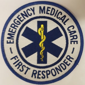 Può includere: Toppa ricamata circolare con bordo blu. Le parole "EMERGENCY MEDICAL CARE - FIRST RESPONDER" sono in bianco. Un simbolo blu a stella della vita è al centro, con un bastone d'Asclepio dorato.