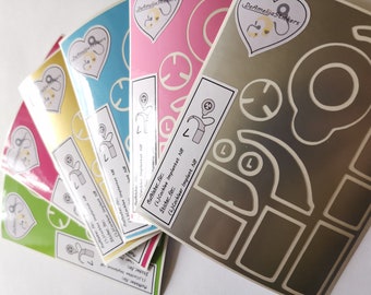 May include: A set of six colorful stickers for cochlear implants. The stickers feature a variety of designs, including a heart with a pair of scissors, a clock face, and a cochlear implant. The stickers are labeled "Sticker for: (L)Cochlear Implant N8".