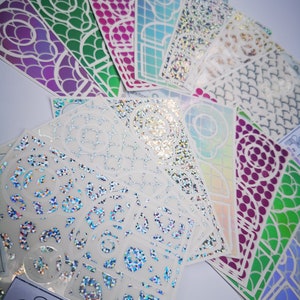 May include: A set of 10 iridescent holographic stickers with various designs, including geometric patterns, glitter, and a sheet of alphabet letters. The stickers are perfect for adding a touch of sparkle to your crafts, journals, and more.