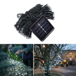 May include: A set of solar powered string lights with a black solar panel. The lights are white and are strung on a black wire. The lights are shown wrapped around a tree branch.