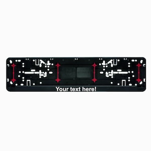 Può includere: Cornice per targa in plastica nera con punti di fissaggio rossi e il testo "Your text here!"