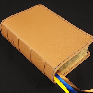 Saddle tan cowhide leather Every Man&#39;s Bible, Large Print with navy blue perimeter stitching and three ribbons