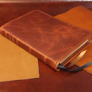 Distressed tan cowhide MacArthur Study Bible with black sheepskin liner and two ribbons