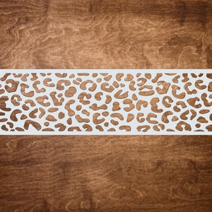 May include: White stencil with a leopard print design. The stencil is made of a thin, flexible material and is perfect for creating a variety of crafts.