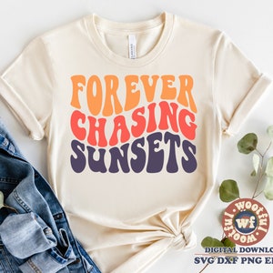 May include: A beige t-shirt with the text "FOREVER CHASING SUNSETS" in a retro, rainbow-coloured font.