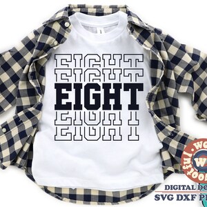Könnte beinhalten: Ein weißes T-Shirt mit dem Wort "EIGHT", das in einem gestapelten Muster wiederholt wird. Das Wort ist in Schwarz und weiß umrandet. Das Shirt ist gefaltet und auf einem karierten Hemd gelegt.