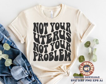 May include: A beige t-shirt with the text "NOT YOUR UTERUS NOT YOUR PROBLEM" in black, stylized lettering.