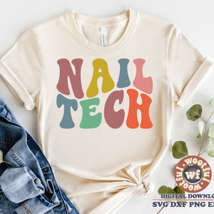 May include: A white t-shirt with the words "NAIL TECH" in colorful retro-style lettering.