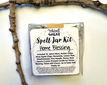 May include: A clear plastic box containing a "Whims and Wilds Spell Jar Kit" for Home Blessing. The kit includes various herbs, a quartz crystal, a dressed candle, twine, and an empty jar. A brown twig is in the foreground.