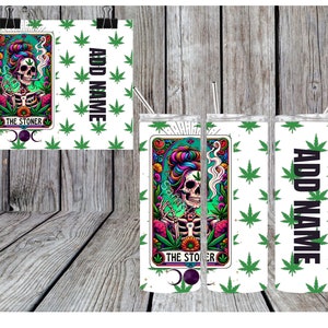 May include: White tumbler and print featuring a tarot card design with a skeleton smoking a cigarette, surrounded by colorful flowers and leaves. The text "THE STONER" is displayed. The background has a cannabis leaf pattern and the text "ADD NAME".