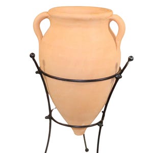 May include: A terracotta amphora with two handles, standing on a black metal stand with three legs.
