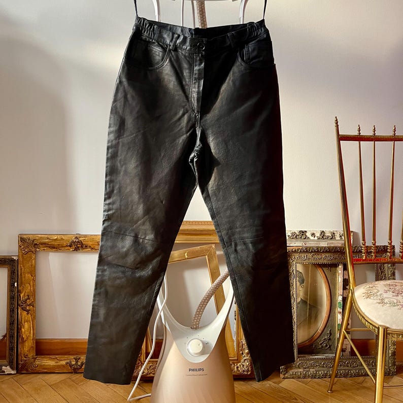 Peut inclure: Pantalon en cuir noir suspendu &agrave; un cintre. Le pantalon est ajust&eacute; et taille haute. Il est en bon &eacute;tat et a un look vintage.
