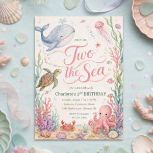 Puede incluir: Una tarjeta de invitación de cumpleaños rectangular con ilustraciones en acuarela de una ballena azul, una tortuga marina, un pulpo rosa, un cangrejo y medusas entre algas y corales. El texto dice: Join us Two the Sea to celebrate Charlotte's 2nd birthday.