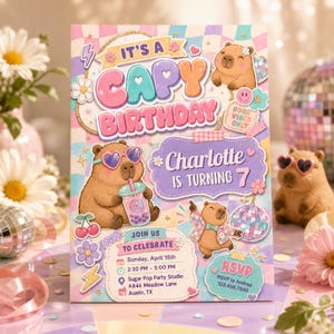 May include: A rectangular birthday invitation card featuring a pastel checkered background, illustrations of capybaras, and the text 'IT'S A CAPY BIRTHDAY', 'Charlotte IS TURNING 7', 'JOIN US TO CELEBRATE', and 'RSVP to Andrea 123.456.7890'.