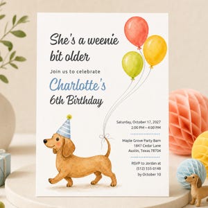 May include: A birthday invitation card featuring a watercolour illustration of a brown dachshund wearing a blue striped party hat. The card includes three balloons in red, yellow, and green, with text reading She's a weenie bit older, Charlotte's 6th Birthday, and event details for Saturday, October 17, 2027, at Maple Grove Party Barn in Austin, Texas.