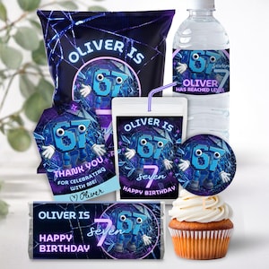 Peut inclure: Ensemble de fournitures de fête sur le thème numérique. Comprend un sachet de chips, une bouteille d'eau, une brique de jus, des autocollants et une barre chocolatée, tous avec le texte "Oliver is Seven Happy Birthday". Un cupcake avec glaçage blanc est également présent.