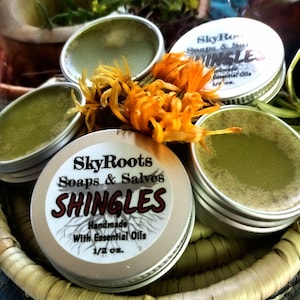 May include: Four small silver tins of salve with green contents and labels that read "SkyRoots Soaps & Salves SHINGLES Handmade With Essential Oils 1/2 oz."