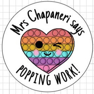 Op de afbeelding: Ronde sticker met een regenboog hart en de tekst "Mrs. Chapaneri says popping work!"
