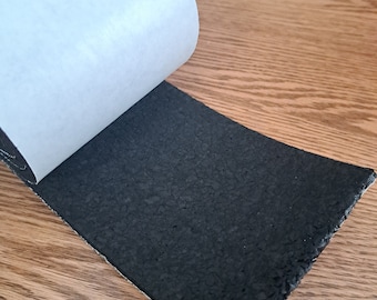 May include: A roll of black adhesive tape with a white backing. The tape is partially peeled back to reveal the adhesive.