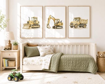 May include: Three framed watercolor prints of construction vehicles: a bulldozer, an excavator, and a dump truck. The prints are in a light-colored wooden frame. The room also features a crib with green bedding and a green tractor toy.