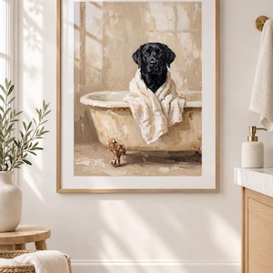 May include: A framed wall art print featuring an oil painting of a black Labrador dog sitting inside a beige clawfoot bathtub. The dog is wrapped in a white towel, and the background depicts a neutral-toned bathroom setting with visible brushstrokes.