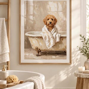 May include: A framed wall art print featuring an oil painting of a golden-brown curly-haired dog sitting inside a vintage clawfoot bathtub. The dog is wrapped in a white towel, and the background depicts a neutral-toned, textured bathroom setting.
