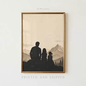 May include: Framed sepia-toned print featuring a family silhouette overlooking a mountain range. The image shows a parent and two children seated on a rock, with the text "PRINTED AND SHIPPED" at the bottom. The artwork is in a gold frame.