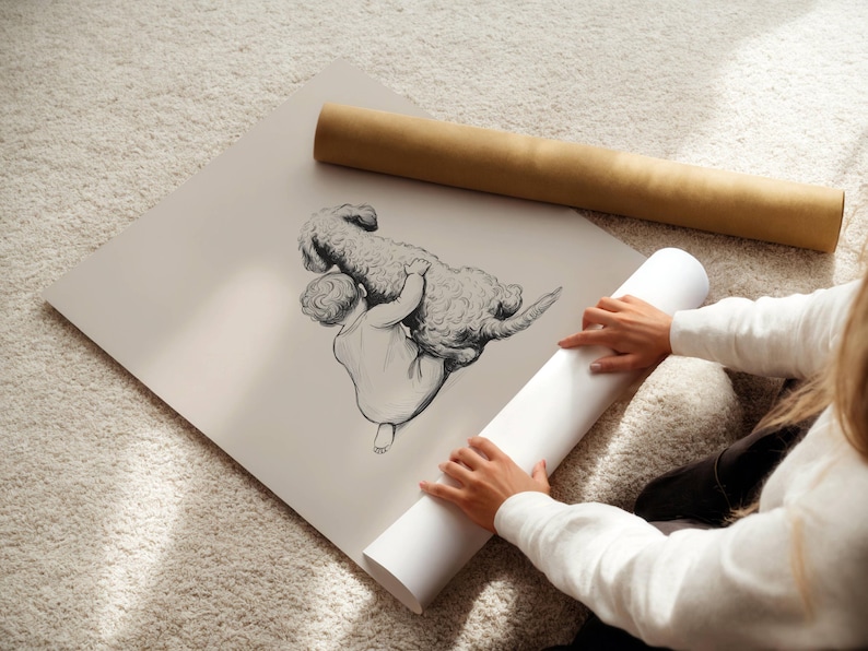 May include: A black and white illustration of a child and a dog. The child is holding the dog. The illustration is on a large, off-white print. A rolled-up print and a brown tube are also in the image.