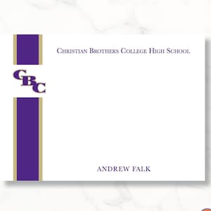 May include: A white 5x7 inch personalized stationery card with a purple and gold stripe design. The card features the text "Christian Brothers College High School" and "Andrew Falk" in purple text. The top left corner of the card features a purple and gold logo with the letters "GBC".