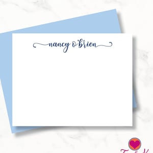 May include: A white stationery card with the name "nancy o'brien" written in navy blue cursive script.