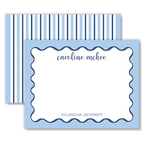 May include: A rectangular stationery card with a light blue scalloped border and a white center. The text "caroline mckee" is printed in dark blue script, and "VILLANOVA UNIVERSITY" in dark blue block letters. An envelope with blue stripes is behind.