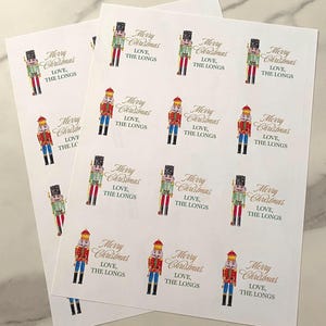 May include: A sheet of 12 nutcracker-themed gift tags with the text "Merry Christmas, Love, The Longs" printed on each tag.