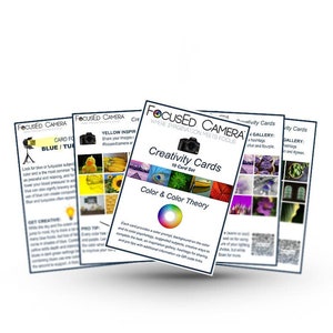 Stack of Creativity Cards for photography showing samples of part of the blue, yellow, purple, and green cards and the cover sheet with a camera on it.