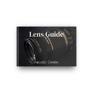 Puede incluir: Un objetivo de cámara negro y plateado con el texto "Lens Guide" y "FOCUSED CAMERA" sobre un fondo negro.