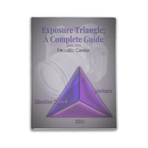 Op de afbeelding: Een boekomslag met een grijze achtergrond en de titel "Exposure Triangle: A Complete Guide" in witte tekst. De ondertitel is "Learn with Focused Camera" in witte tekst. Een camera lens is gedeeltelijk zichtbaar op de achtergrond. Een paarse en blauwe driehoek bevindt zich op de voorgrond met de woorden "Aperture", "Shutter Speed" en "ISO" op elk punt.