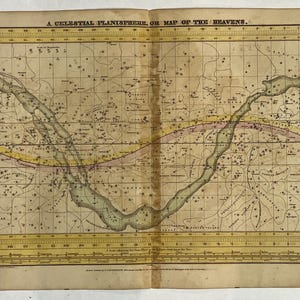 May include: An antique celestial planisphere or map of the heavens. The map features a detailed illustration of the night sky with constellations, lines, and text. The map is printed on aged paper with a yellow and brown color scheme.