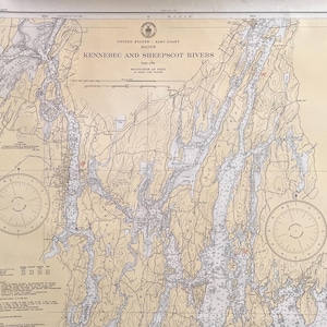 May include: A nautical chart titled United States East Coast Maine Kennebec and Sheepscot Rivers. The map features beige land areas, blue water, and black text detailing soundings in feet at mean low water, with two compass roses included.