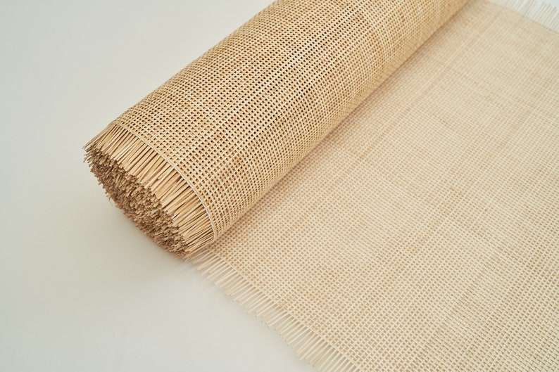May include: A roll of natural cane webbing, a woven material used for chair seats and other furniture projects. The webbing is beige in colour and has a natural, slightly rough texture.