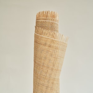 May include: A roll of natural-coloured cane webbing, a woven material used for chair seats and other furniture upholstery.