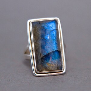 May include: A silver ring with a rectangular blue labradorite gemstone set in a bezel setting.