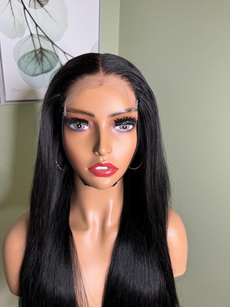 Puede incluir: Una peluca larga y lisa de cabello humano negro con un frente de encaje. La peluca est&aacute; en una cabeza de maniqu&iacute;.