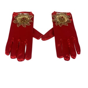 Puede incluir: Un par de guantes de satén rojo con adornos florales dorados en la parte posterior de cada mano.