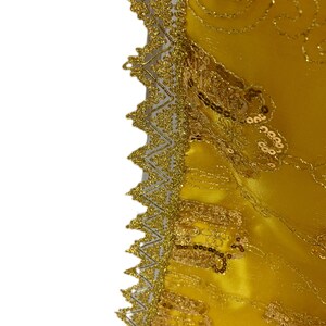 May include: A yellow fabric with gold embroidery and sequins along the edge.